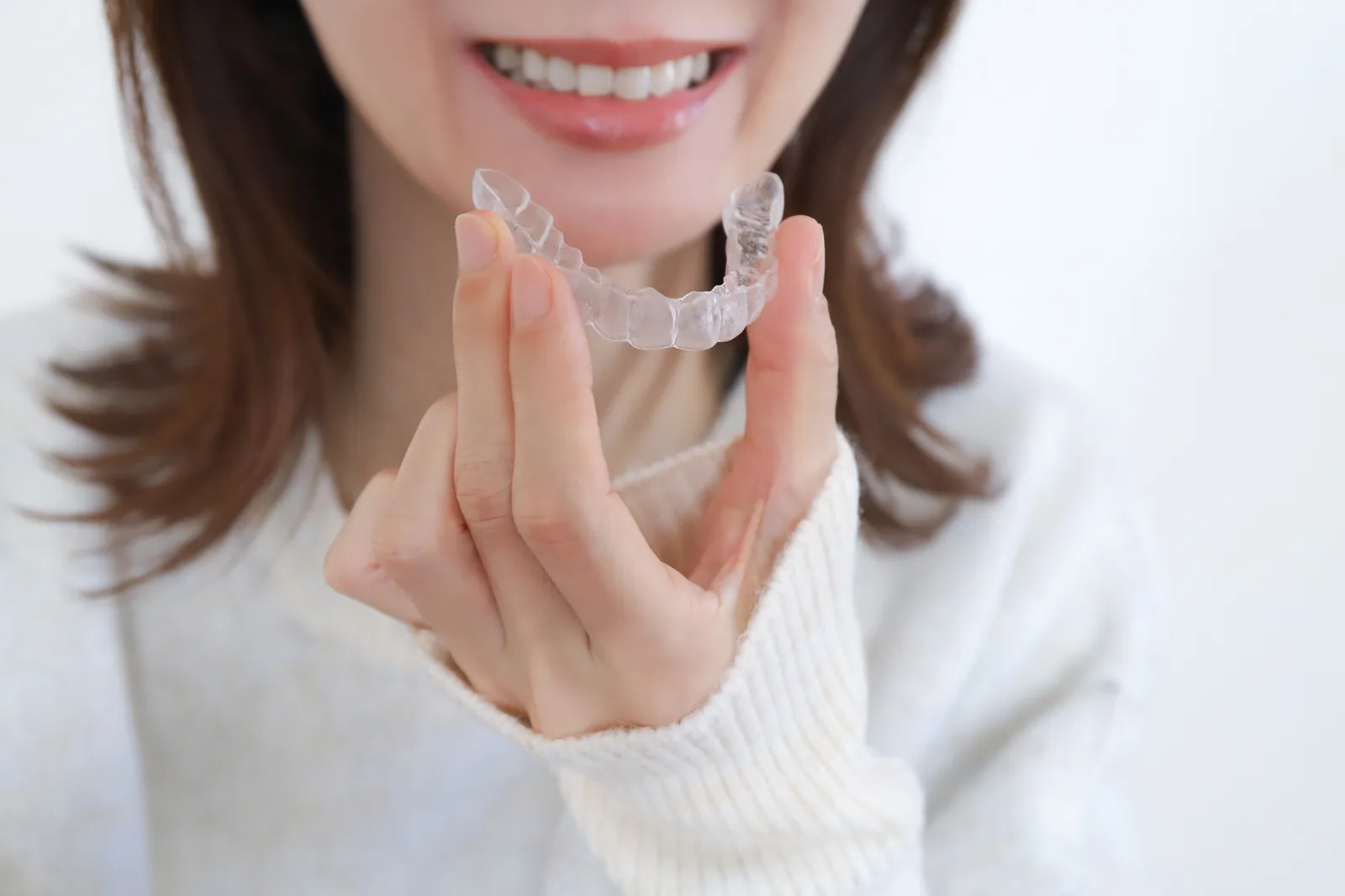マウスピース型矯正装置を手にする女性（イメージ）